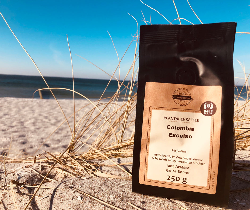 Bild zeigt eine Packung Thieme Kontor Kaffee der Sorte Colombia Excelso am Strand von Zingst. Im Hintergrund der Ostsee-Strand.